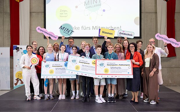 Gruppenfoto mit allen Sieger:innen der MINT Challenge 2026 und Partner:innen sowie Jury