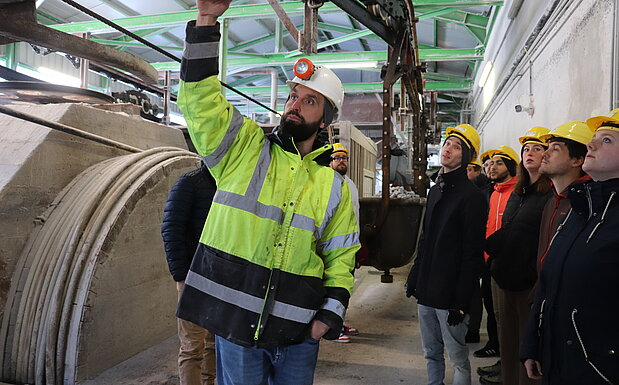 Auf dem Bild ist eine Gruppe Studierender bei einer Besichtigung zu sehen