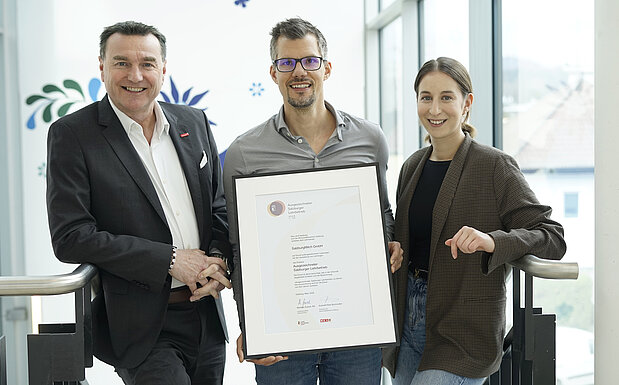 Auf dem Bild sind drei Personen von Salzburg Milch mit Urkunde zu sehen